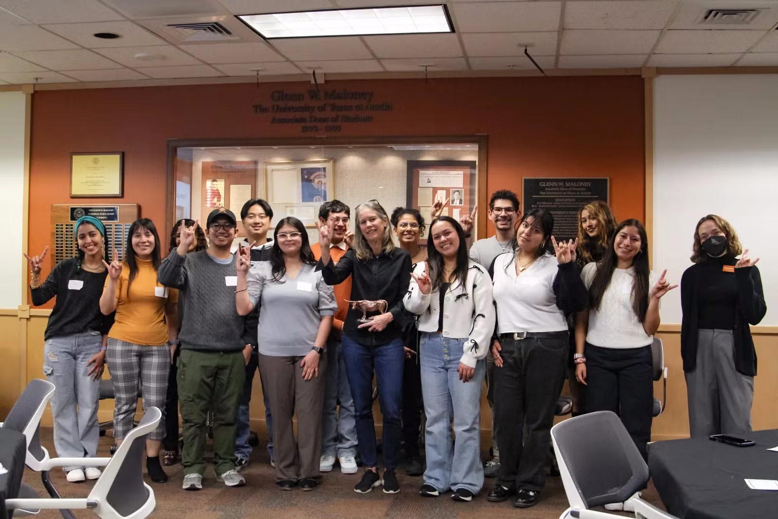 A group of 14 students pose for a photo with an HHH advisor