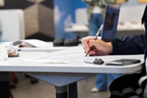 Image of person sitting at a table writing