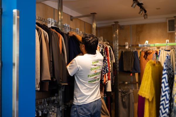 A volunteer hangs clothing in the UT Outpost clothes closet